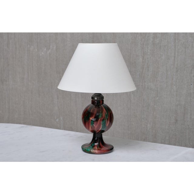 This rare table lamp was produced by Böhlmarks in Sweden in the 1920s, with the glass base crafted at Pukebergs Glasbruk,...
