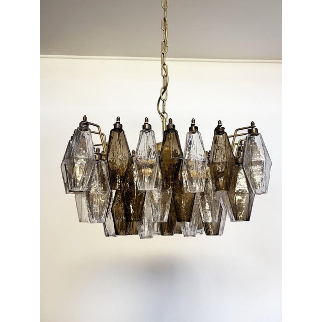 Elegant italian chandelier made from 56 beautiful murano clear and smoked glasses "poliedri". Structure in gold and brass...