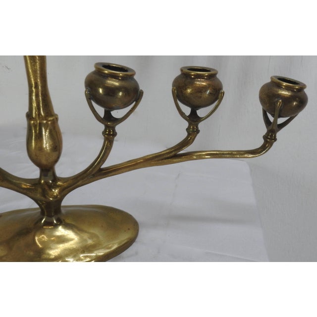 A lovely Tiffany gilt bronze six-arm candelabra from the Art Nouveau period. Six candle sconces are raised on supports....