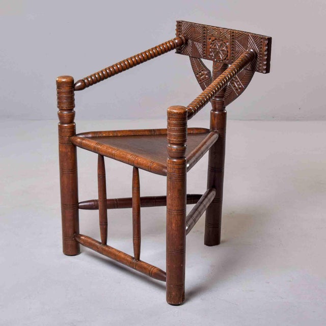Found in England, a rare corner armchair of exceptional craftsmanship featuring a triangular solid oak seat and...