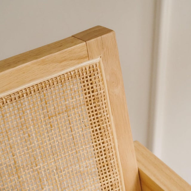 Contemporary armchair in ash wood with a woven back and seat. The angular construction with angled legs and clearly...