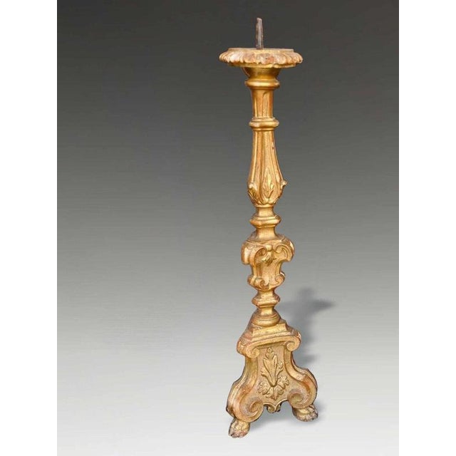 A highly decorative 18th-century Italian Baroque ecclesiastical candle stand, finely carved in limewood and finished with...