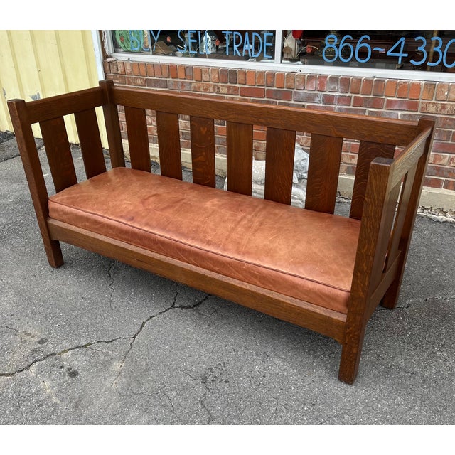 An authentic early 20th-century Mission oak settle by L. & J.G. Stickley, branded “The Work of L. & J.G. Stickley.” This...