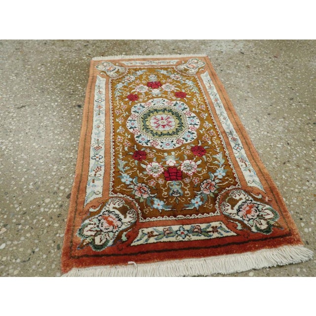 This Mid-20th century Persian Silk Quom rug, measuring 1' 0" x 1' 8", embodies the refined artistry and luxurious...