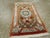 This Mid-20th century Persian Silk Quom rug, measuring 1' 0" x 1' 8", embodies the refined artistry and luxurious...