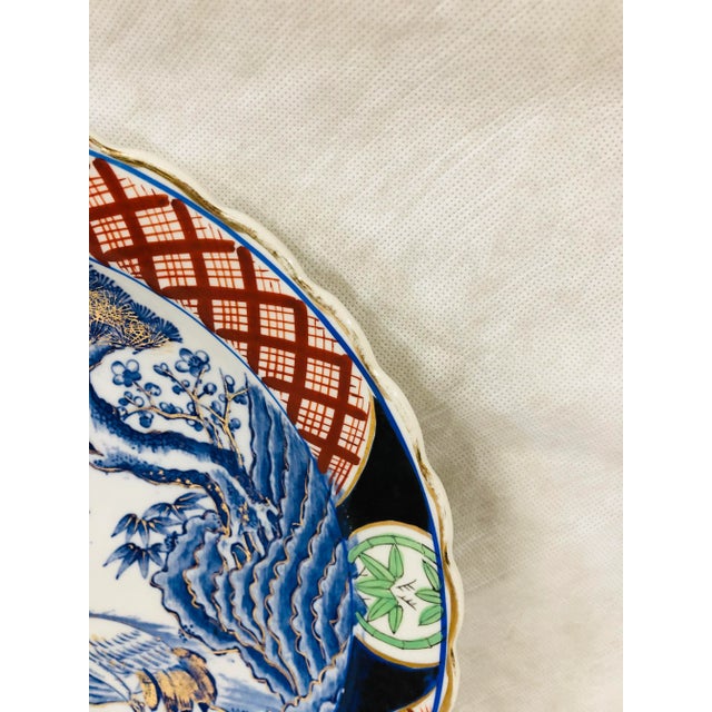 Large orange and blue Asian pottery charger with center bird design. Back is also decorated with blue koi. Marked with...