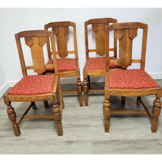 Set of four antique English oak dining chairs, circa 1920s, featuring distinctive geometric splat backs, turned front legs...