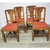 Set of four antique English oak dining chairs, circa 1920s, featuring distinctive geometric splat backs, turned front legs...