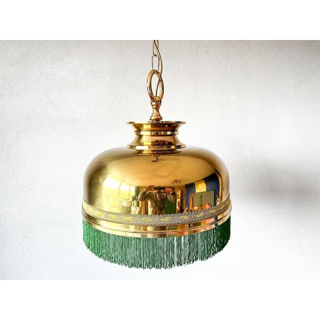 This vintage pendant lamp adds a touch of nostalgia to any room. with its gold metal finish and green fringes, it's a real...