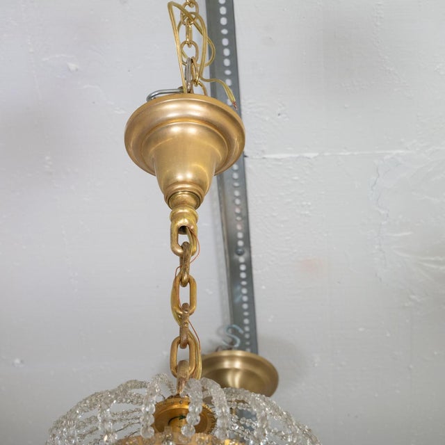 Gilt metal finish chandelier featuring various styles of crystal drop elements and cast flower bobeches.