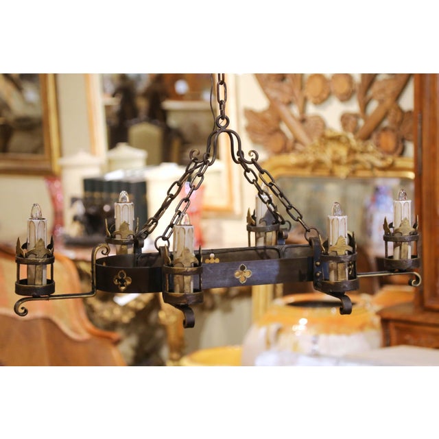This antique French chandelier blends Gothic Revival character with a restrained, architectural silhouette. Crafted in...