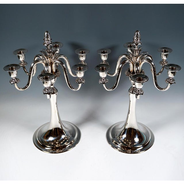 Simple elegance with that certain something: two six-flame candleholders on a round, smooth base with fluted stepped rim,...