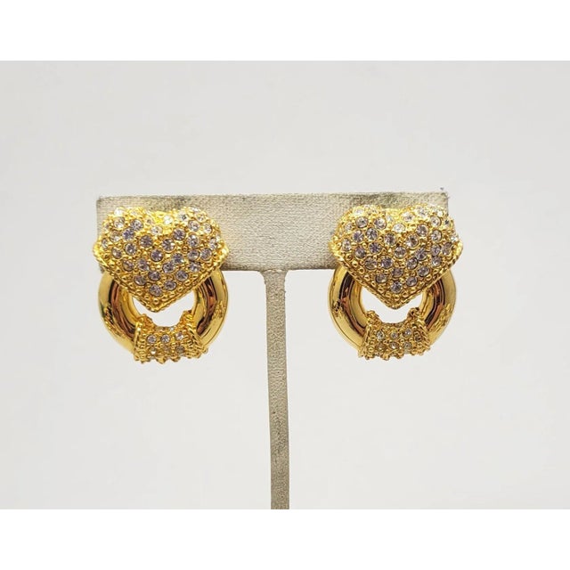 This is part of Chairish’s Costume Jewelry assortment. 1990s goldtone pave round clear Swarovski rhinestones heart top and...