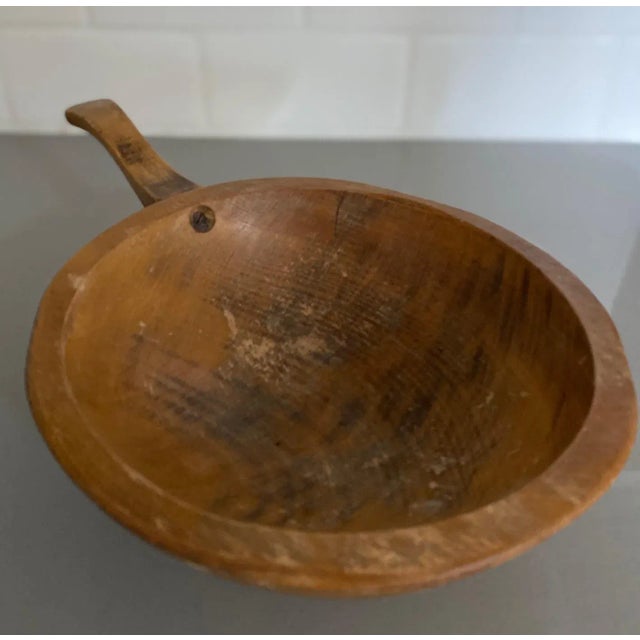 Beautiful hand carved round wood bowl with handle. No makers mark. Would be a wonderful addition to a kitchen to...