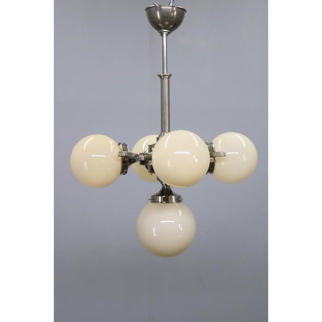 An elegant and authentic art deco chandelier from 1930s czechoslovakia, crafted with a nickel-plated metal frame and five...