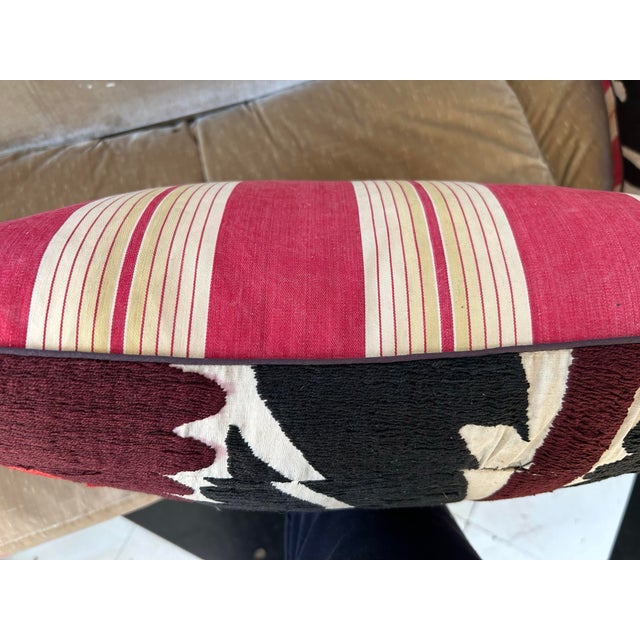 A pillow made from a hand embroidered Suzani coverlet and antique ticking stripe