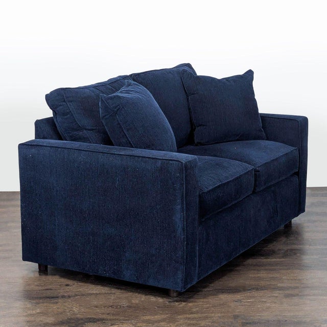 This Room and Board loveseat features a simple, modern design and comes in a rich navy blue fabric. It offers thick...