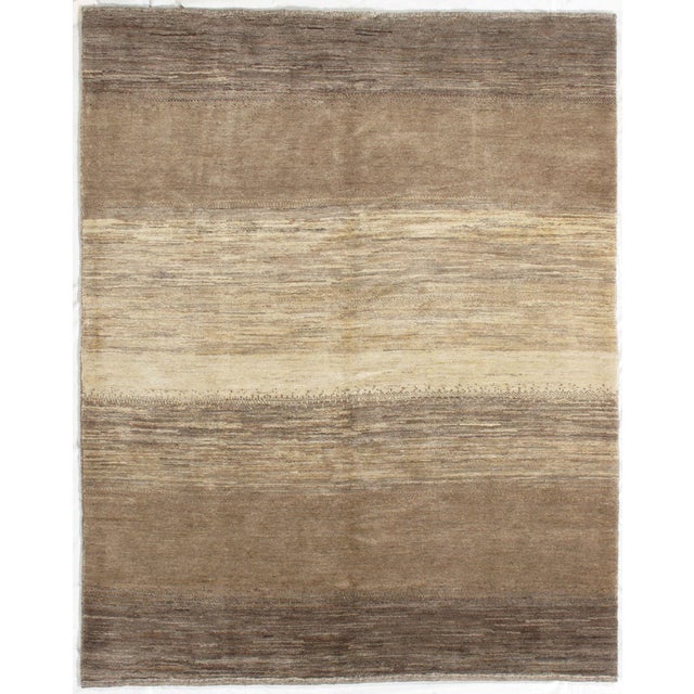 Hand-knotted Persian Lori Gabbeh rug featuring a softly striated composition in warm earth tones. Horizontal bands of...