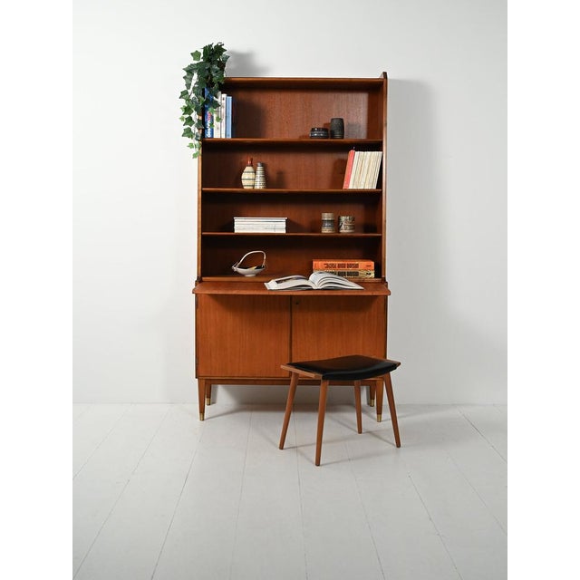 Swedish teak bookcase from the 1950s by Bodafors with a pull-out shelf, lower doors, two internal bentwood drawers, and a...