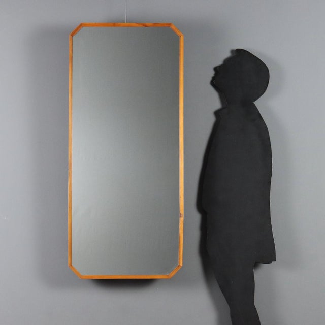 A 1960s Italian-made wall mirror featuring a finely crafted walnut frame. The elongated shape and beveled edges lend the...
