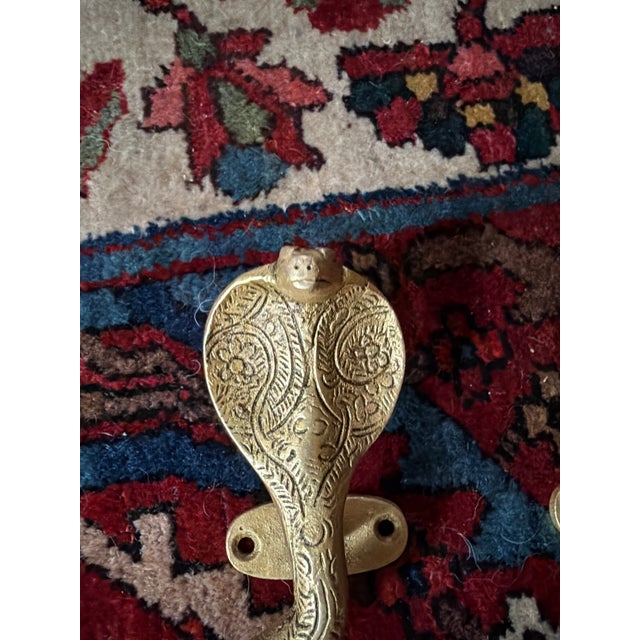 This is a pair of striking Vintaged gold brass cobra door handles with incised decoration in the Hollywood Regency and...