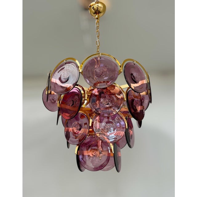 Italian chandelier with burgundy colored hand blown Murano glass discs mounted on gold finish metal frame with decorative...