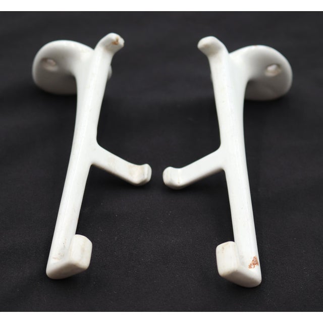 Vintage surface mount shelf brackets made of white enameled cast iron. The original mounting screws are not available....