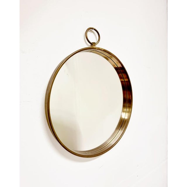 Pocketwatch shaped mirror with brass frame. Sold through Firma Svenskt Tenn, Stockholm, 1950/60s. with beautiful patina...