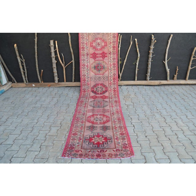 This spectacular Turkish long runner rug was handmade in Anatolian lands in the mid 20th century. This Vintage Oushak...