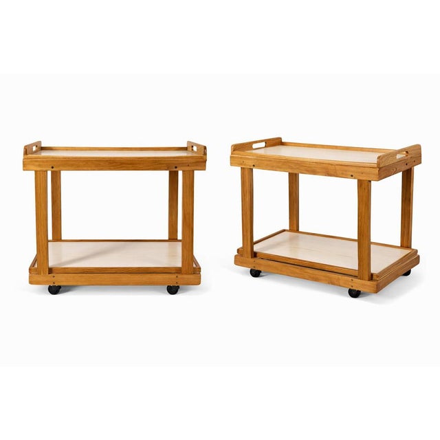 A charming mid-century oak drinks trolley featuring contrasting Formica shelves, combining practicality with classic retro...