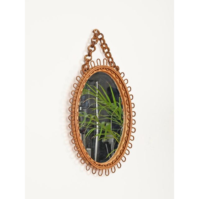 Stunning Mid-Century oval mirror with chain fully made in curved rattan and bamboo. This delightful organic mirror was...