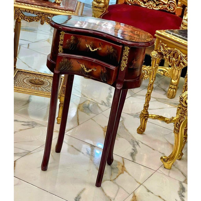 This elegant French style accent table features a rich mahogany-toned finish enhanced by hand-painted decorative artwork...