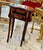 This elegant French style accent table features a rich mahogany-toned finish enhanced by hand-painted decorative artwork...
