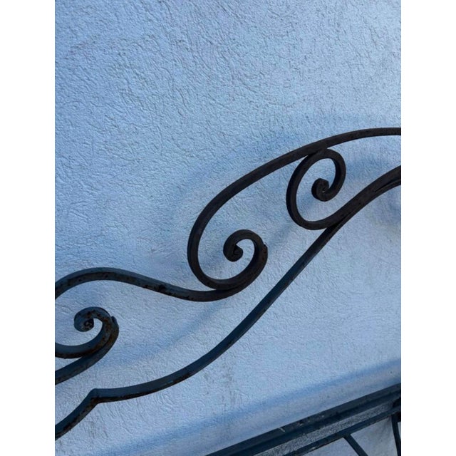 A rare and elegant antique wrought iron garden chaise longue, showcasing remarkable craftsmanship with scrolls entirely...