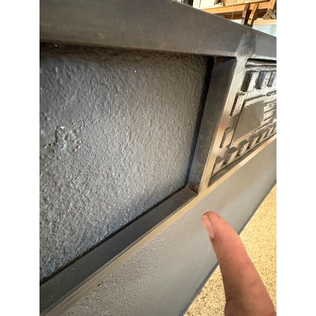 This mirror features a dark gray metal frame with prominent geometric square textured pattern with pyramid details.