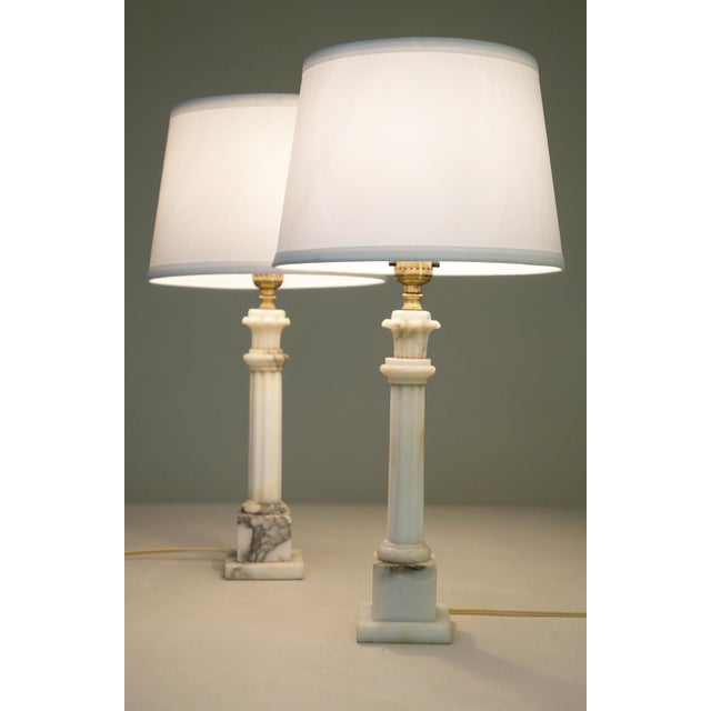 A sophisticated pair of Italian Carrara marble Classic Hollywood Regency Corinthian Column style table lamps from Italy...