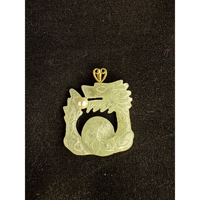 This lovely 14K green jade dragon pendant with a freshwater pearl accent is a unique and eye-catching piece of fine...