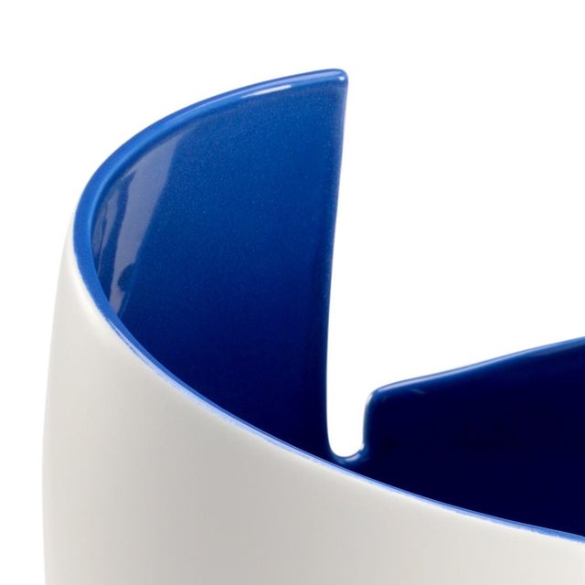 White glazed contemporary porcelain vase with blue glaze interior. 14.8h x 3.8w x 3.8d