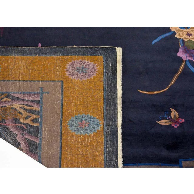 A gorgeous early 20th century Chinese Art Deco rug with large clusters of multicolored lotus and chrysanthemums in each...