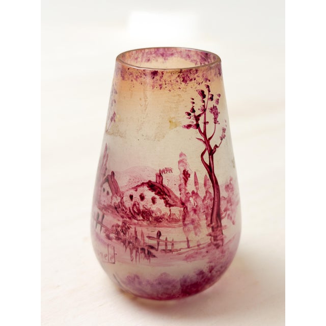 A petite and charming art nouveau glass vase from verrerie de laignelet features a cold-painted panoramic scene of the...