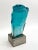 Large carved glass face. Signed on side of face. Dimensions: (Glass) H 15" x W 8" x D 9" (On stand) H 18.5" Pascal,...