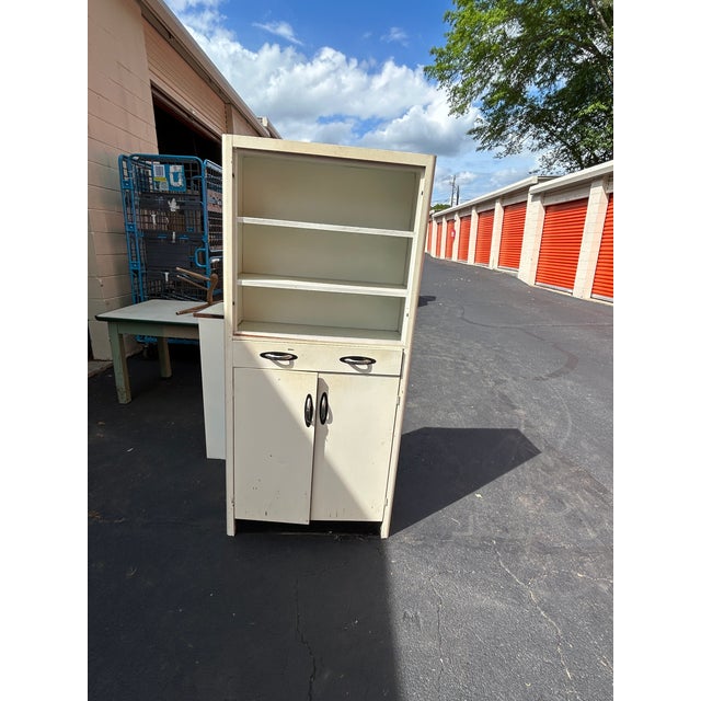 **Description:** Authentic vintage white enameled metal kitchen hutch dating to the 1940s–1950s. This classic utility...