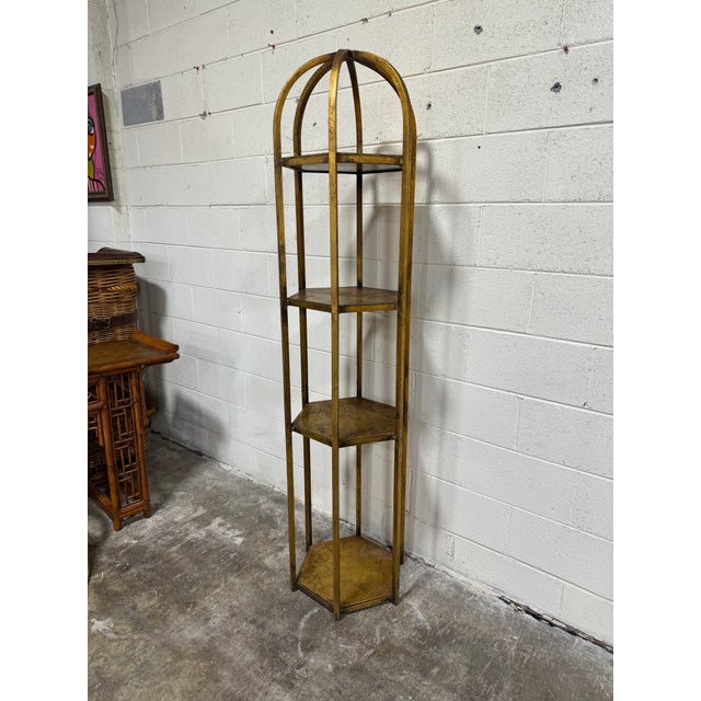 Not sure how old, but definitely vintage. Iron welded frame that has been gilded and wood insert shelves. Solid condition....