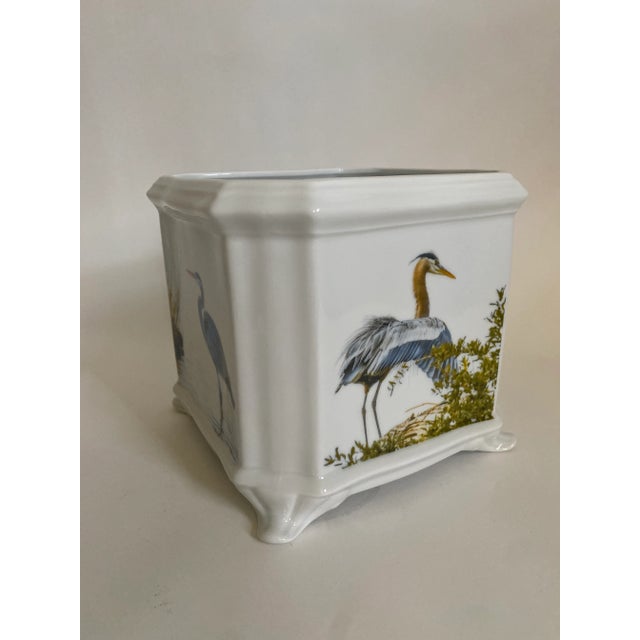 French style square porcelain cachepot with images of a wading heron on two sides and a nesting heron on the other two sides.