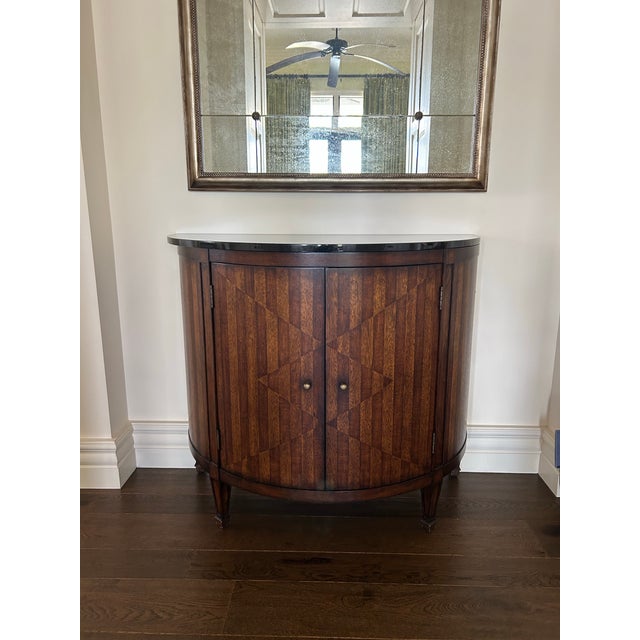 A sophisticated demilune cabinet by Hickory Chair, showcasing the brand’s signature craftsmanship and refined design. This...