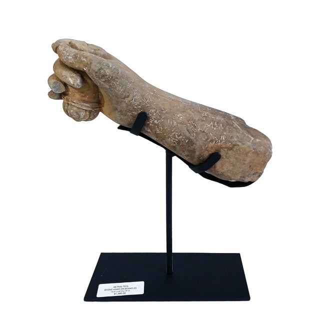 A hand fragment holding a scroll, reclaimed from a Khmer stone statue. East Thailand, early 20th Century. Hand-carved in...