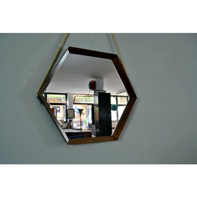 Hexagonal teak mirror made in Italy in the 1960s. The rope that supports it has been replaced. Intact and well preserved....