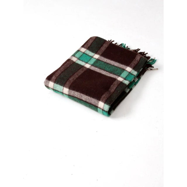 A vintage wool throw by Amana Woolen Mills, woven in a timeless brown and green plaid and finished with classic fringe...