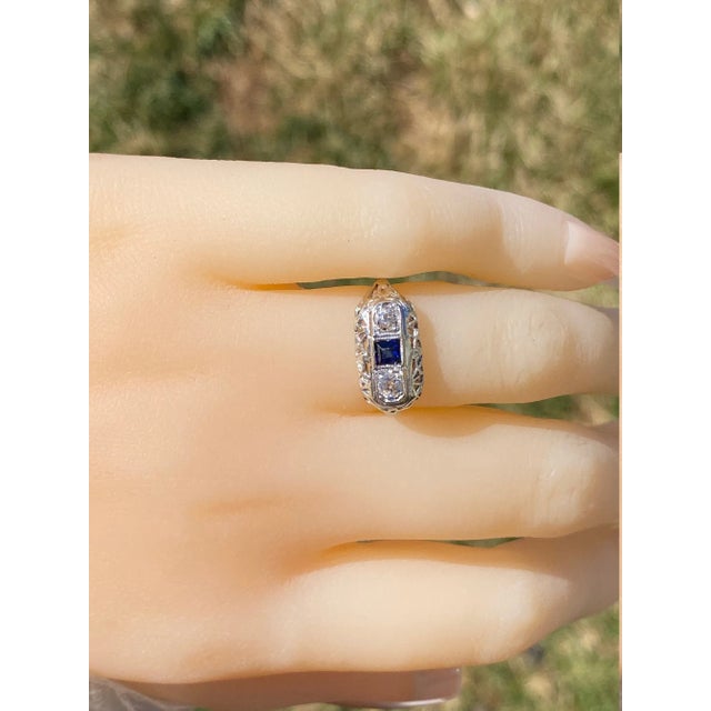 The Kangaroo Island: Antique Filigree Ring set with Sapphire and Diamonds. The ring features a carre cut medium dark blue...