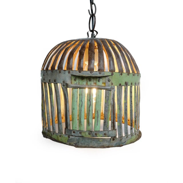 Vintage Indian iron cage basket thoughtfully repurposed into a one-of-a-kind pendant light, celebrating the raw beauty of...